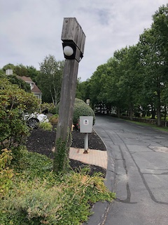 leaning lightpost
      near the mailboxes